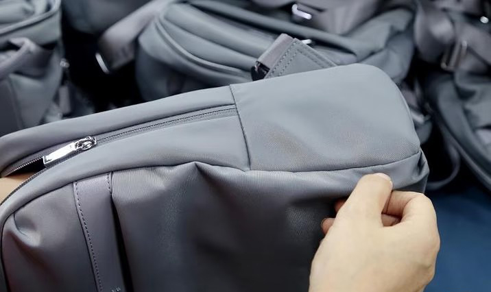 Close-up quality inspection of a bag seam and zipper